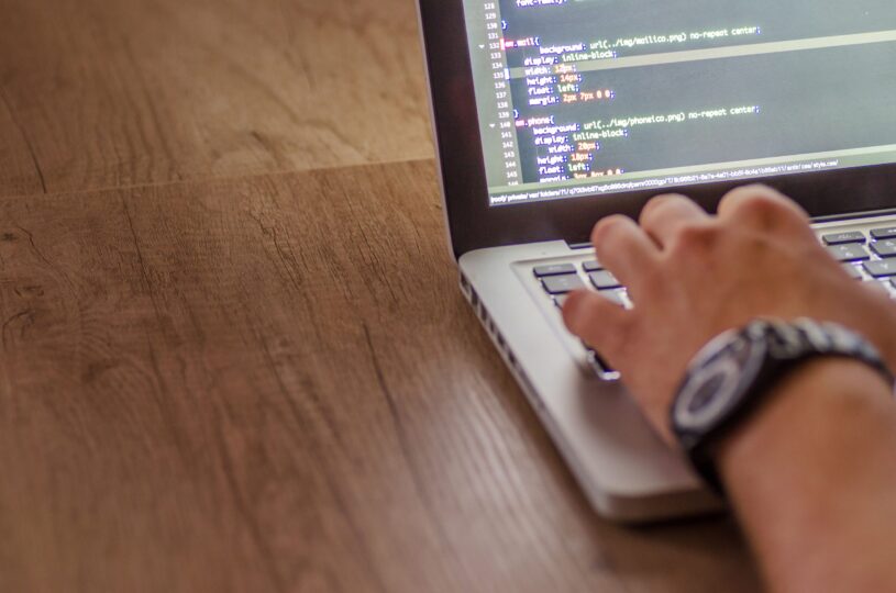 Close-up of a developer writing code on a laptop for website performance optimization